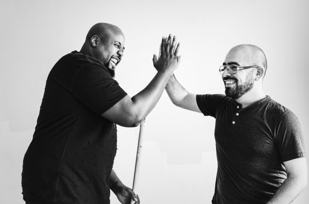 Two members of the Noble House team sharing a high-five.