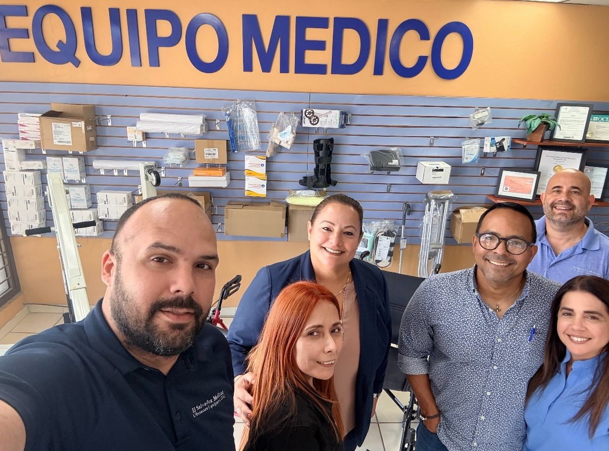 A group photo taken in a stockroom with product shelving behind.